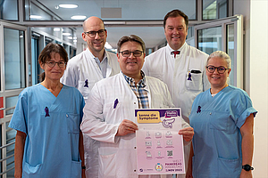Team von Ärzten und der Pflege tragen zum Welt-Pankreaskrebstag 2023 eine lila Schleife