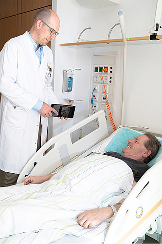 Arzt Patienten Gespräch am Patientenbett